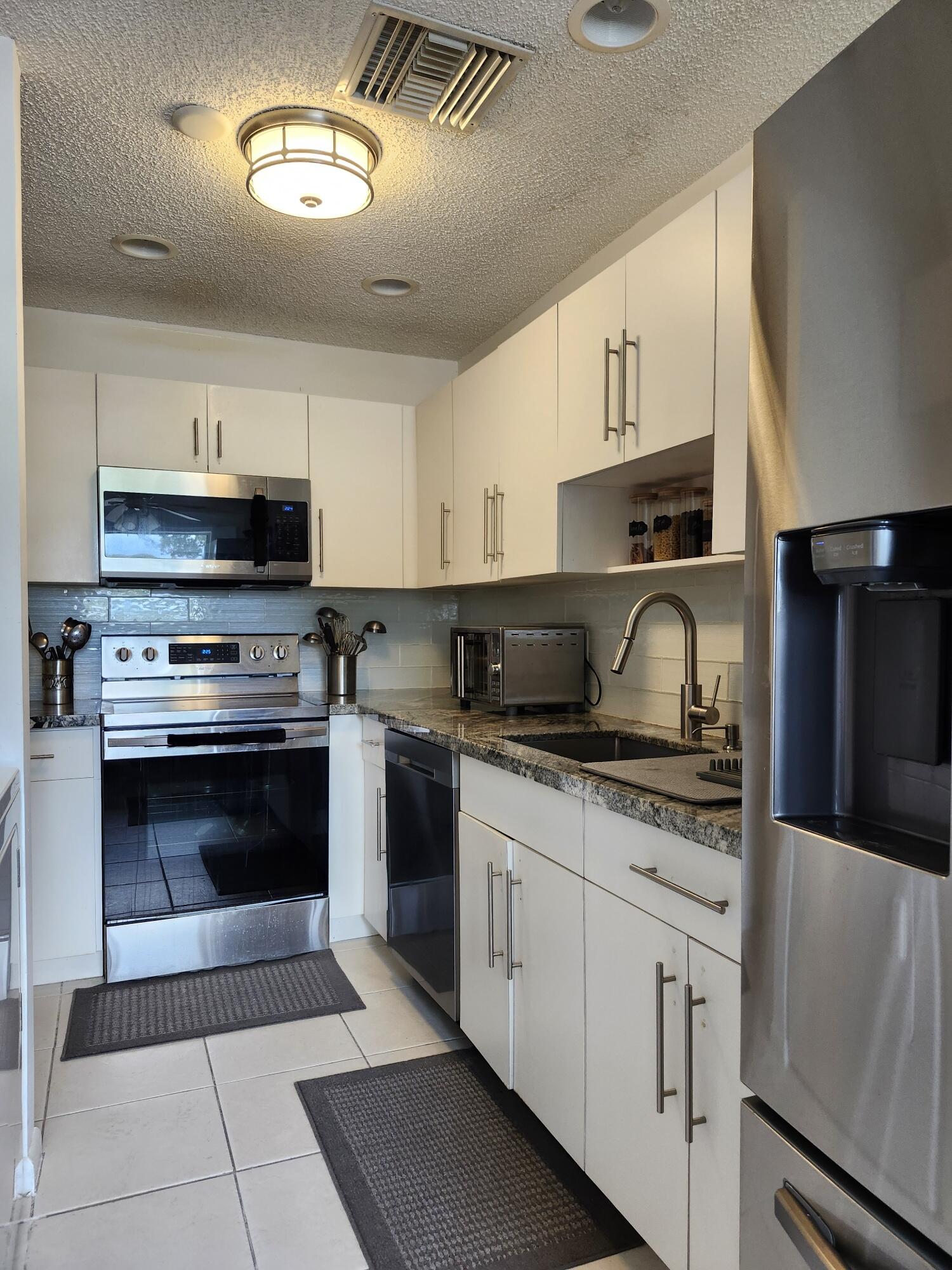 a kitchen with stainless steel appliances granite countertop a stove sink and cabinets