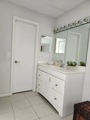 a bathroom with a granite countertop sink a mirror a vanity and a window