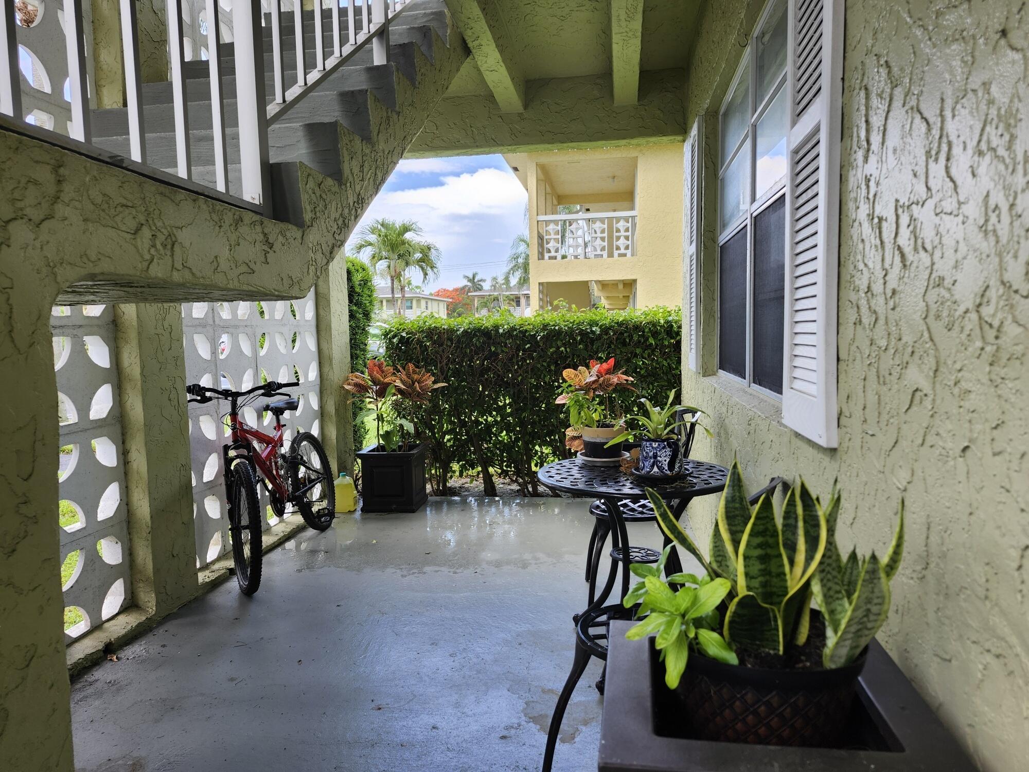 1141 Calamondin Terrace, Unit 101 Delray Beach, FL 33445 - Photo 3 of 21 a view of a chairs and table in a patio