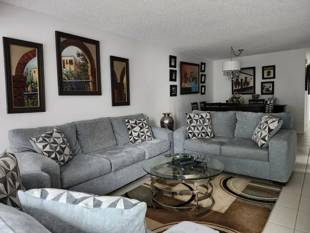 a living room with furniture a couch and painting on the wall
