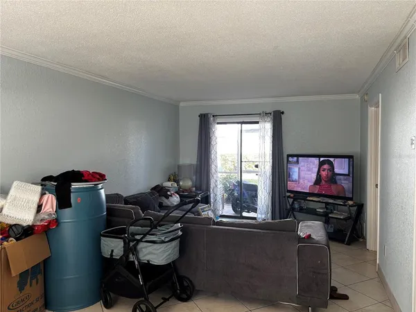 a living room with furniture a flat screen tv and a window
