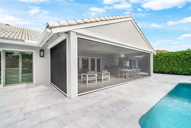 a living room with furniture a flat screen tv and kitchen view