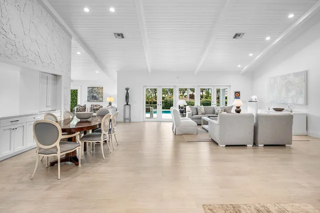 a living room with furniture a dining table and a potted plant