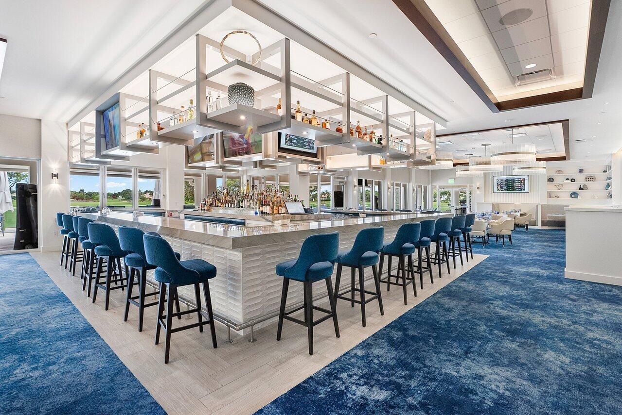 4199 Bocaire Boulevard Boca Raton, FL 33487 - Photo 67 of 82 a dining room with stainless steel appliances kitchen island a table chairs in it and wooden floors