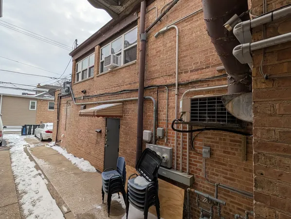 a view of a brick house with a table and chairs