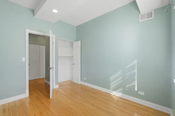 a view of empty room with wooden floor