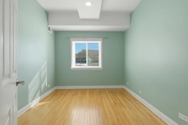 an empty room with a window and wooden floor