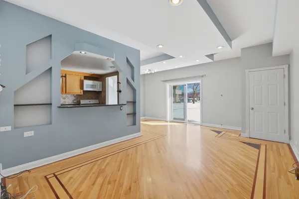 a view of a room with wooden floor and a ceiling fan