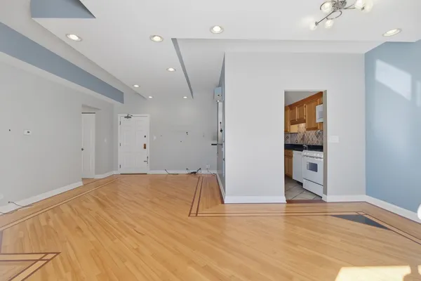 a view of empty room with wooden floor