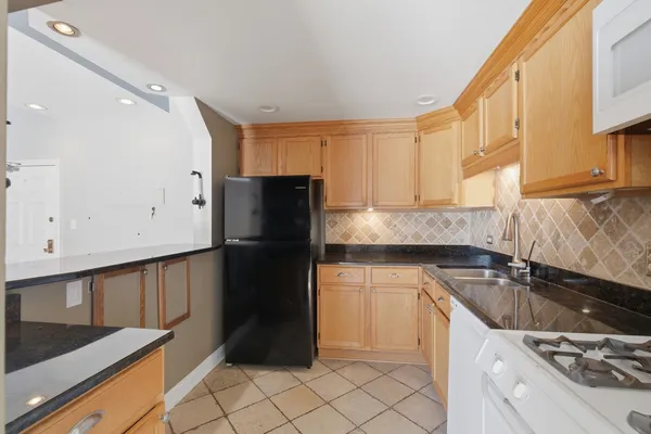 a kitchen with a sink a refrigerator and cabinets