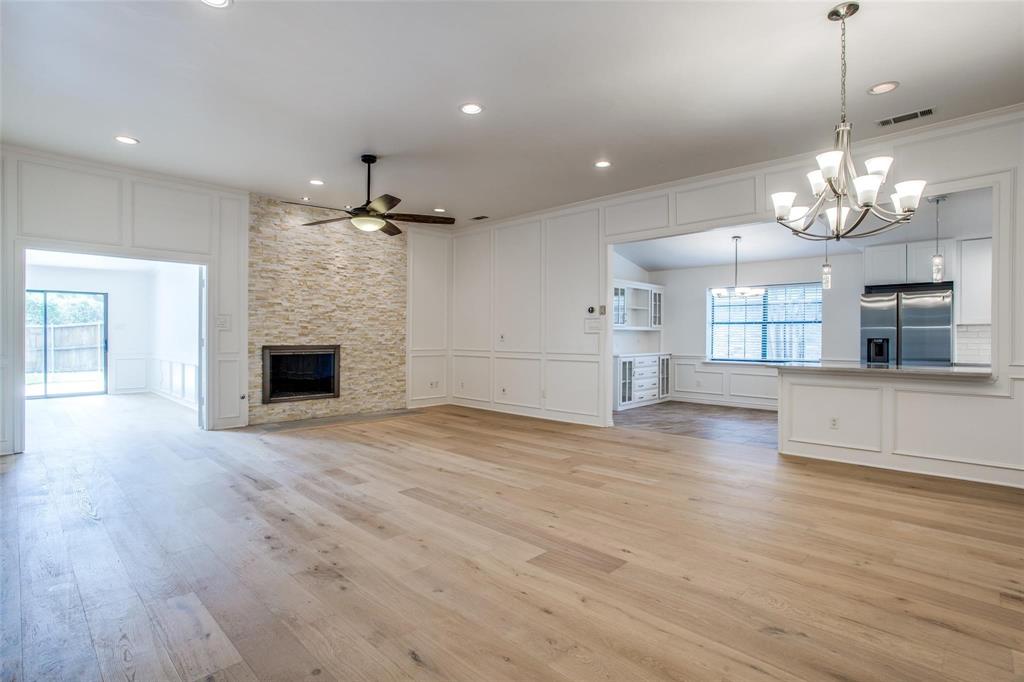 6926 Northwood Road Dallas, TX 75225 - Photo 7 of 29 a view of a livingroom with a fireplace wooden floor and chandelier