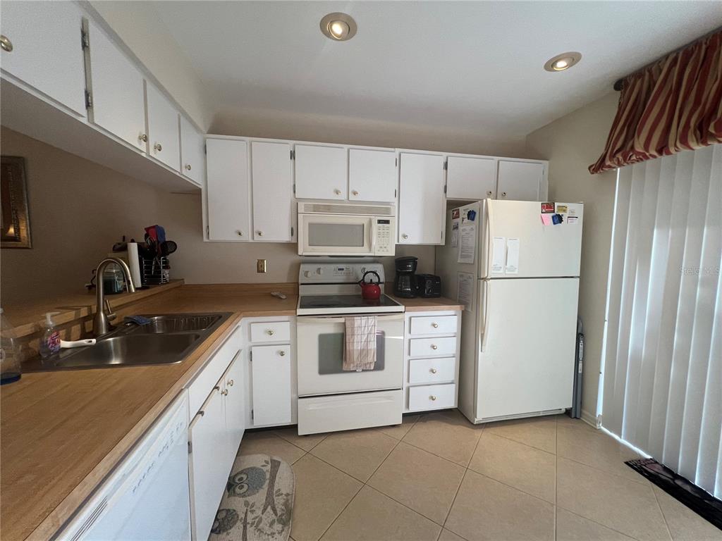 338 Cerromar Way, Unit 4 Venice, FL 34293 - Photo 20 of 41 a kitchen with white cabinets and white appliances