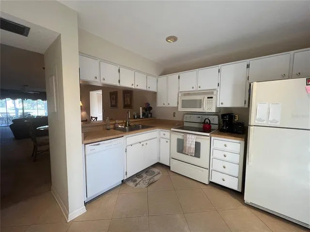 a kitchen with white cabinets and white appliances