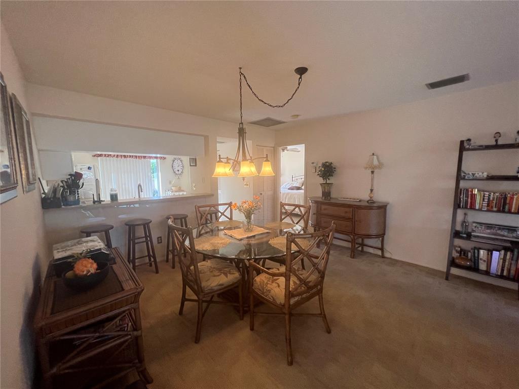 338 Cerromar Way, Unit 4 Venice, FL 34293 - Photo 7 of 41 a dining room with furniture and a book shelf