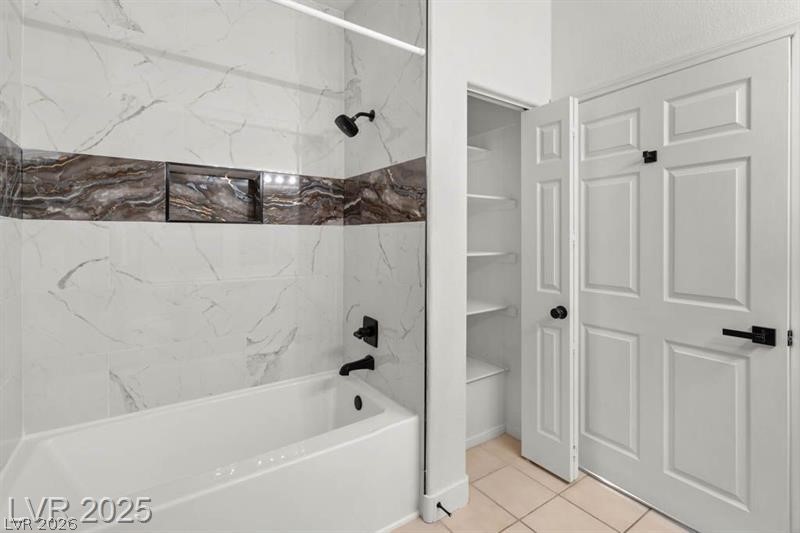 3320 South Fort Apache Road, Unit 125 Las Vegas, NV 89117 - Photo 13 of 26 A well-appointed bath features a tiled tub and shower, alongside a convenient linen closet with built-in shelving.