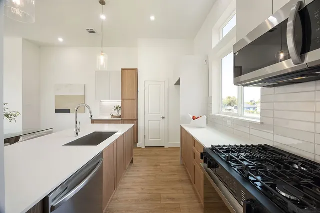 a kitchen with stainless steel appliances granite countertop a sink stove and refrigerator