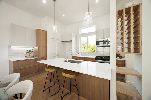 a kitchen with granite countertop a sink a counter space appliances and cabinets