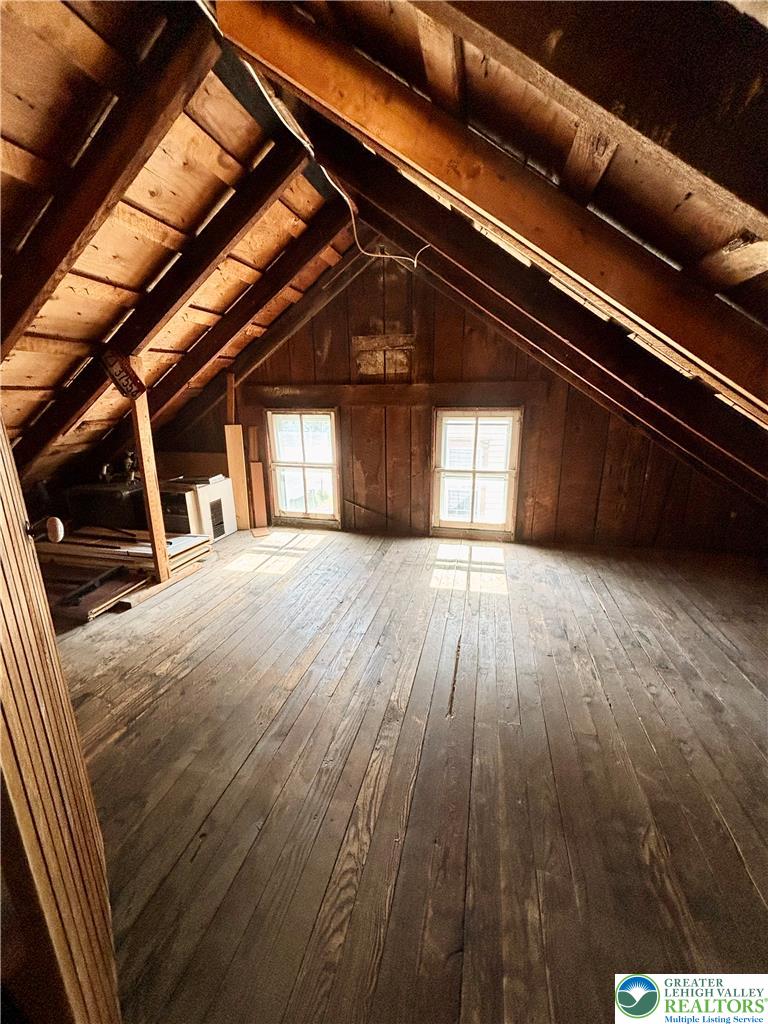 7241 Decatur Street New Tripoli, PA 18066 - Photo 28 of 36 An unfinished attic space offers potential for customization and expansion with exposed wooden beams and floorboards.