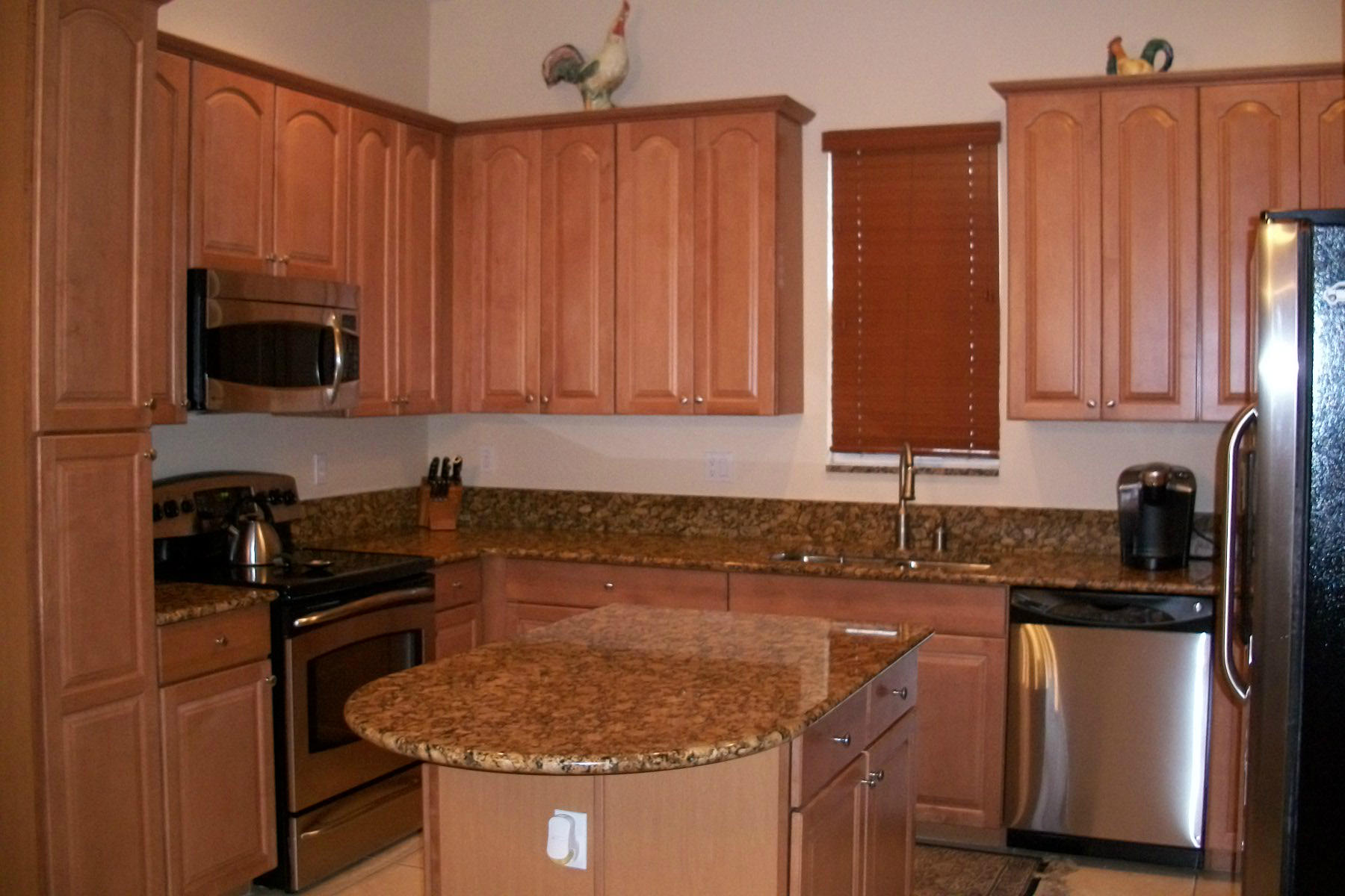 822 Northwest 82nd Place Boca Raton, FL 33487 - Photo 7 of 22 a kitchen with stainless steel appliances granite countertop a sink stove and refrigerator