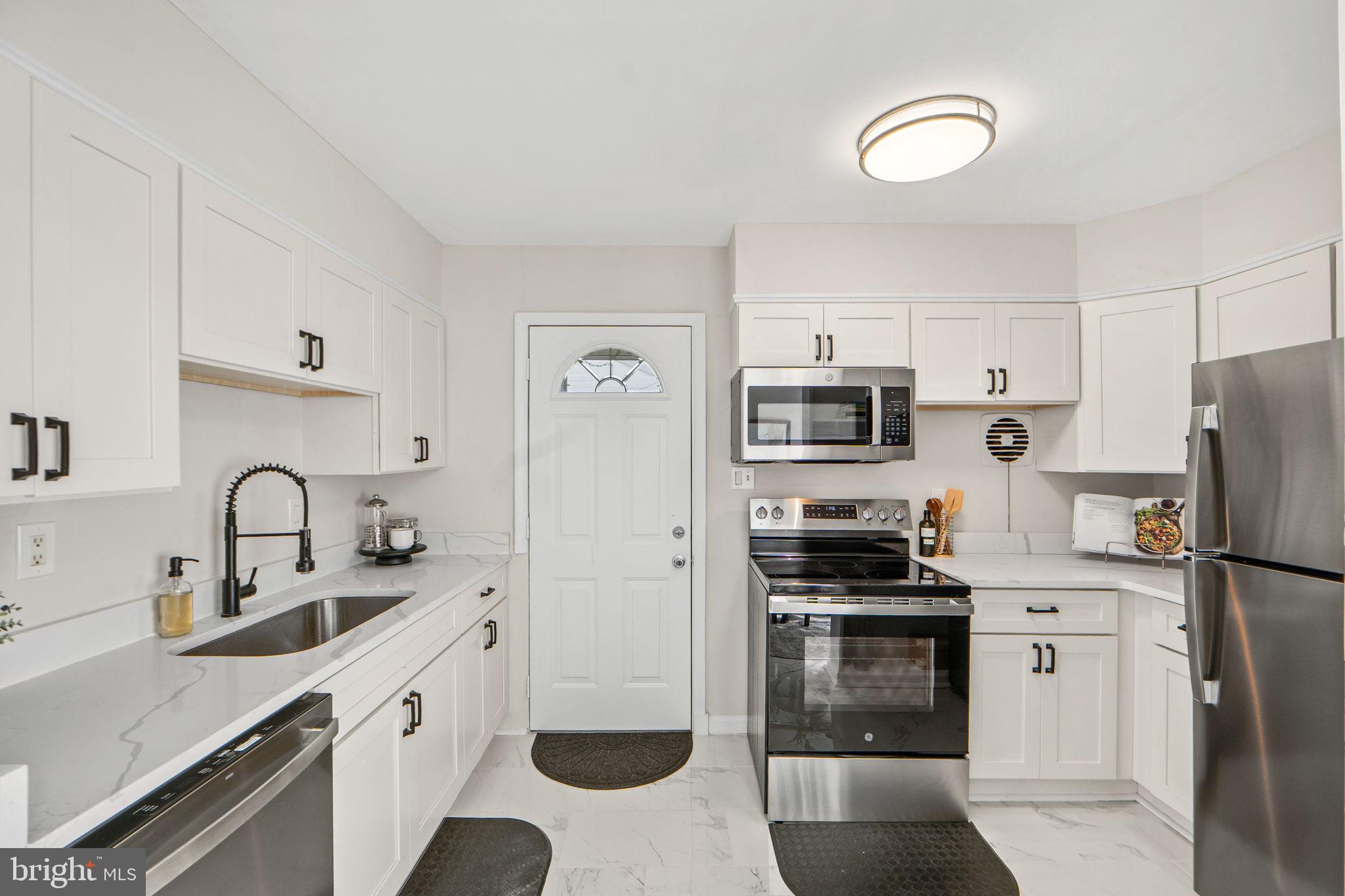 1513 Flora Lane Silver Spring, MD 20910 - Photo 14 of 49 a kitchen with stainless steel appliances a refrigerator stove and sink