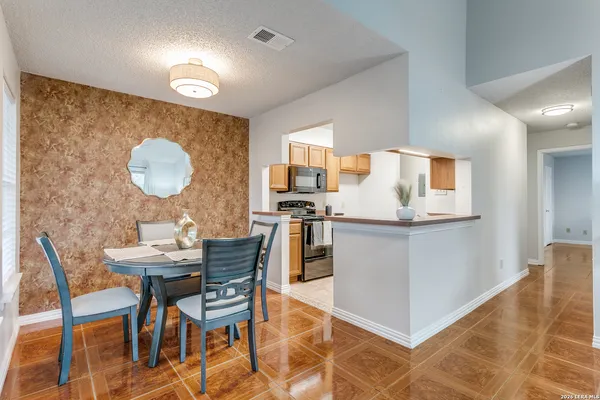 a kitchen with stainless steel appliances granite countertop a stove a sink a microwave a dining table and chairs