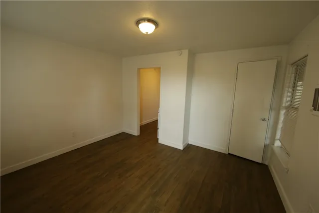 an empty room with wooden floor and closet