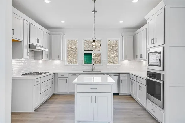 a kitchen with white cabinets and white appliances