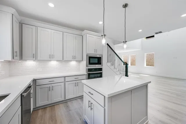 a kitchen with a sink a microwave and cabinets