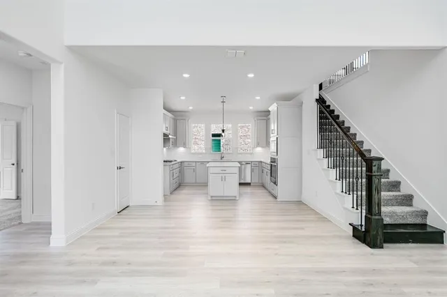 a view of a kitchen with wooden floor and electronic appliances