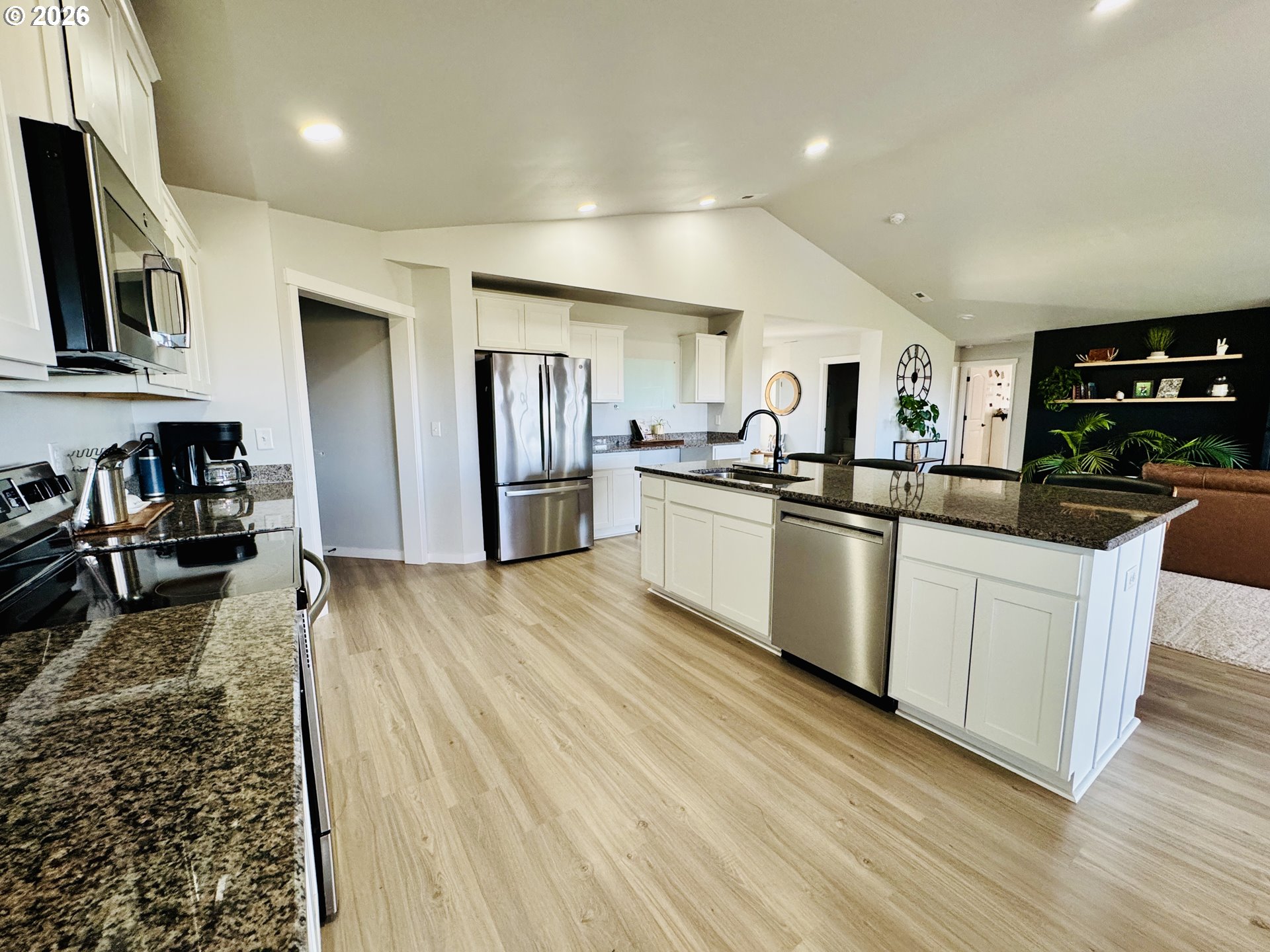 74969 Washington Lane Irrigon, OR 97844 - Photo 13 of 33 a kitchen with stainless steel appliances granite countertop a refrigerator a sink dishwasher a stove top oven a dining table and chairs with wooden floor