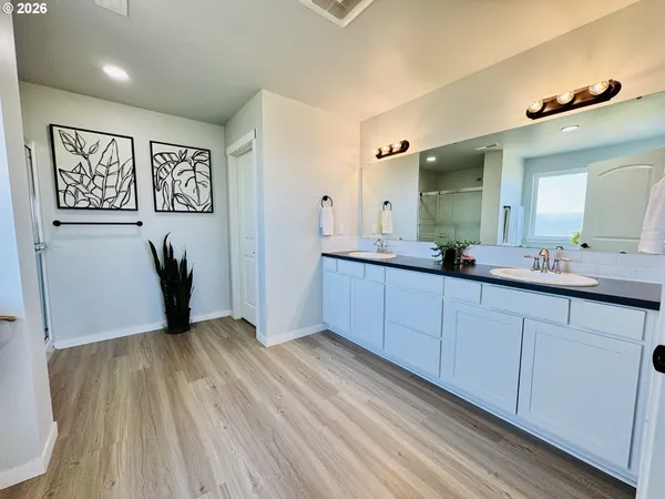 a bathroom with a glass shower door and a sink