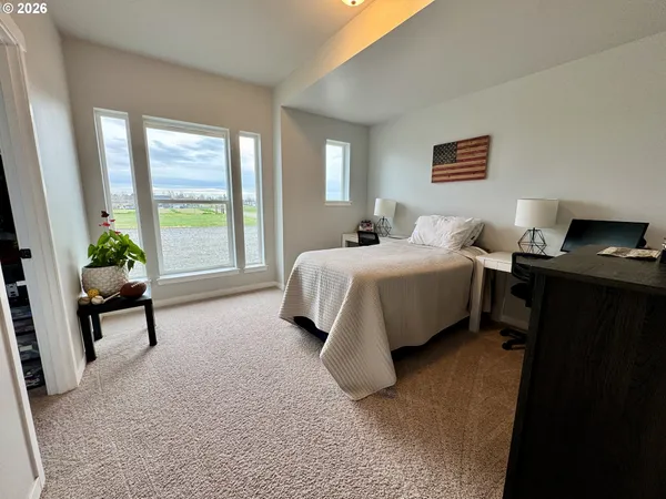 a bedroom with bed and a flat tv screen on dresser
