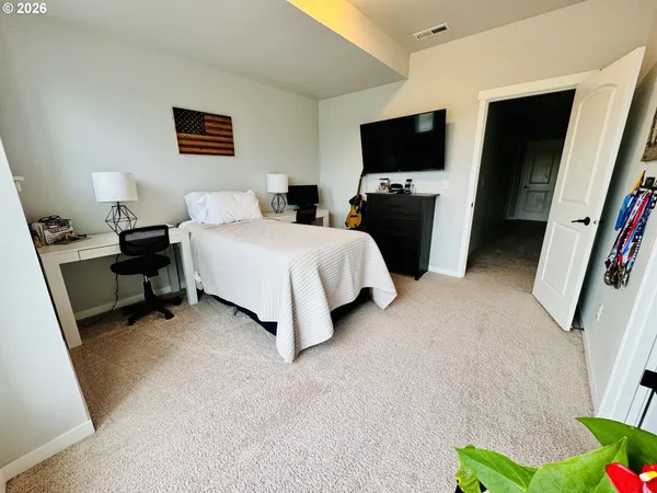 a bedroom with furniture and a flat screen tv