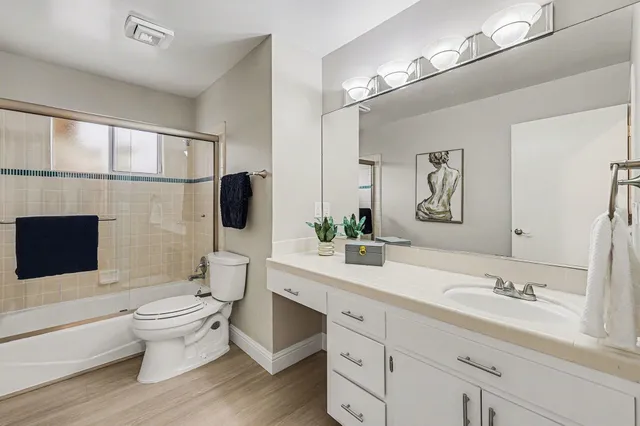 a bathroom with a double vanity sink toilet mirror and shower
