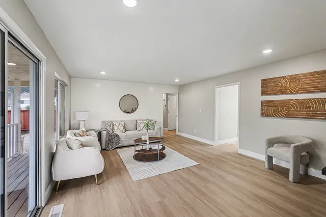 a living room with furniture and a wooden floor