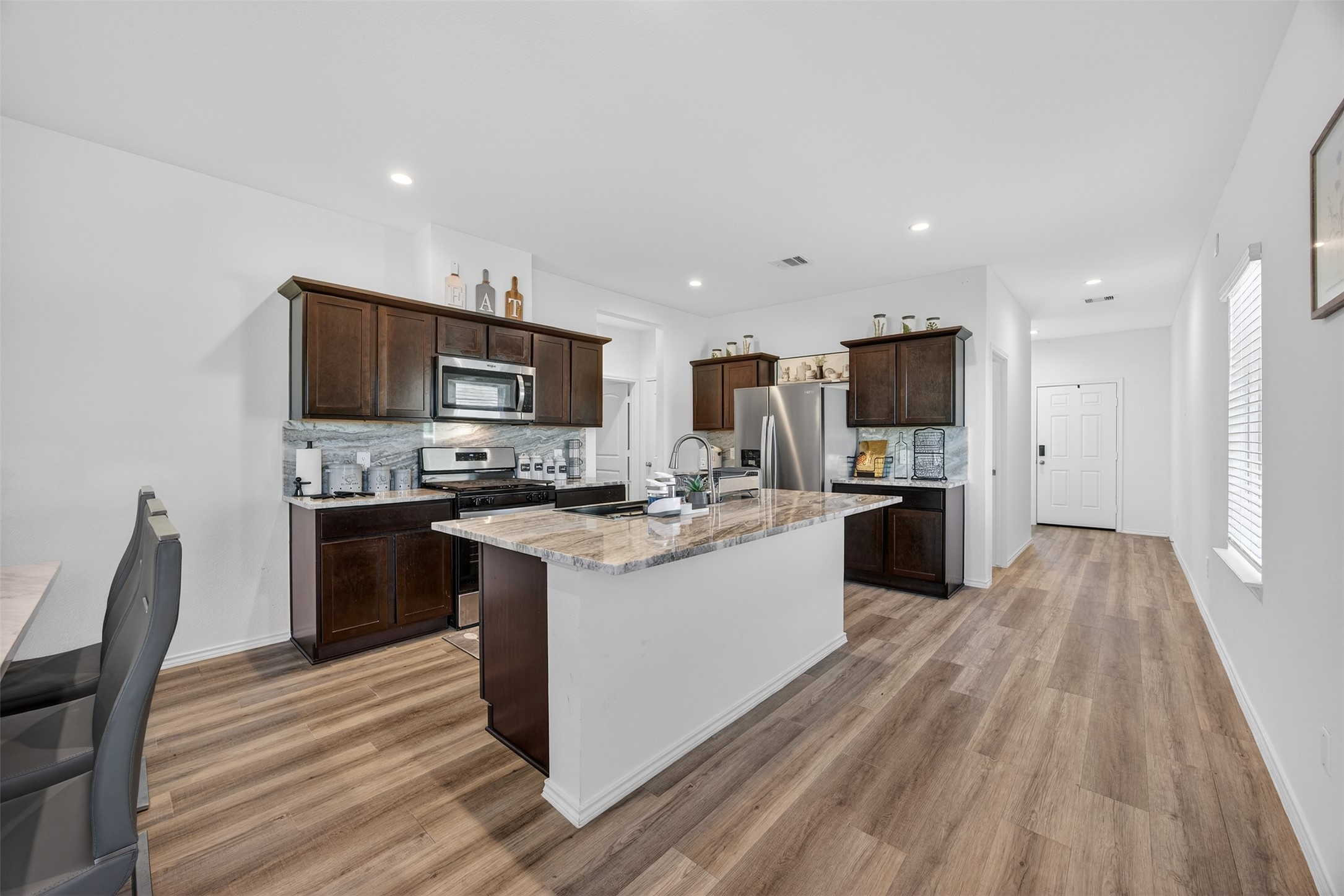 1702 Legacy Hills Drive Houston, TX 77067 - Photo 16 of 43 a kitchen with kitchen island granite countertop stainless steel appliances and wooden cabinets