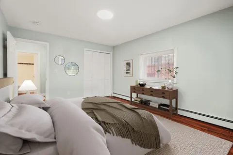 a bedroom with a bed and a lamp on dresser