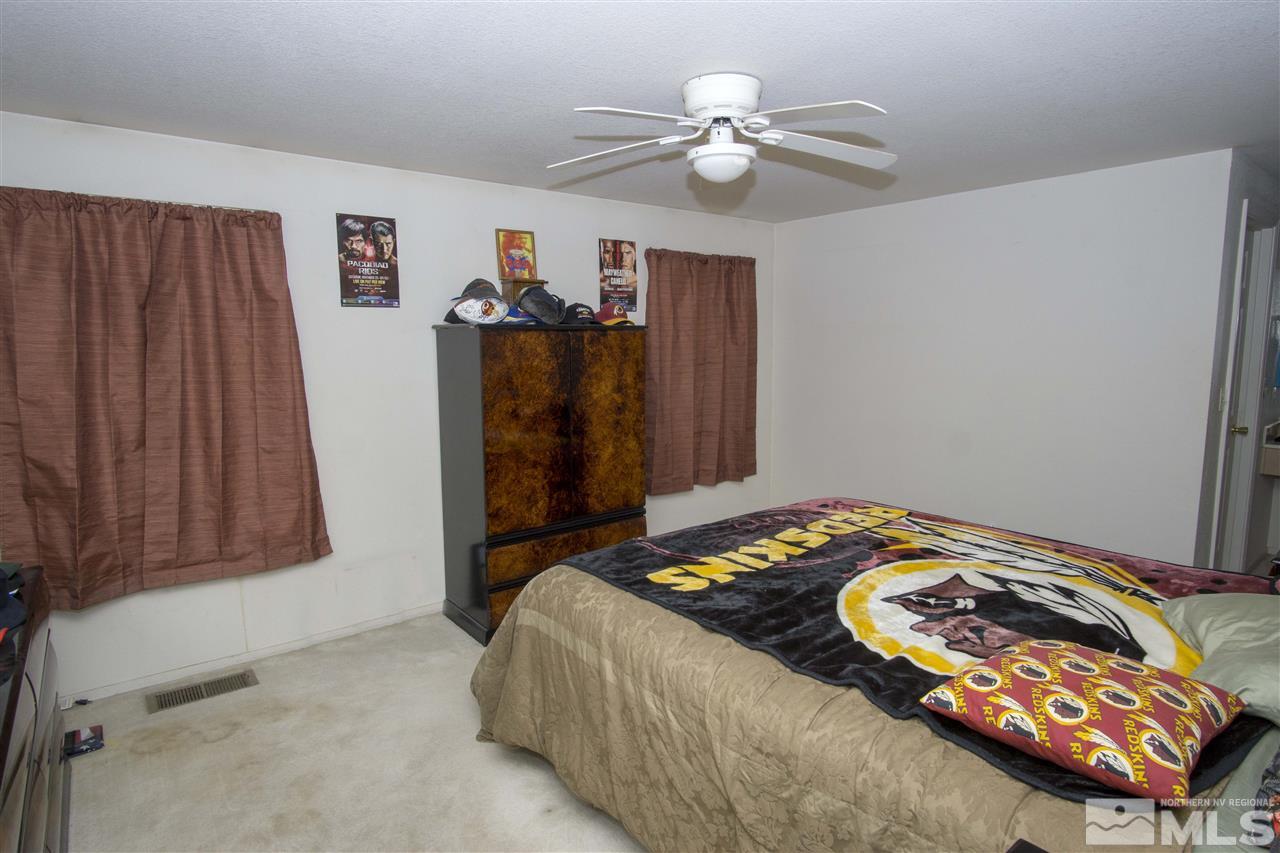 17180 Touraco Street Reno, NV 89508 - Photo 5 of 12 a bedroom with a bed and a chandelier