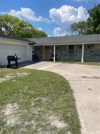 front view of a house with a yard and potted plants