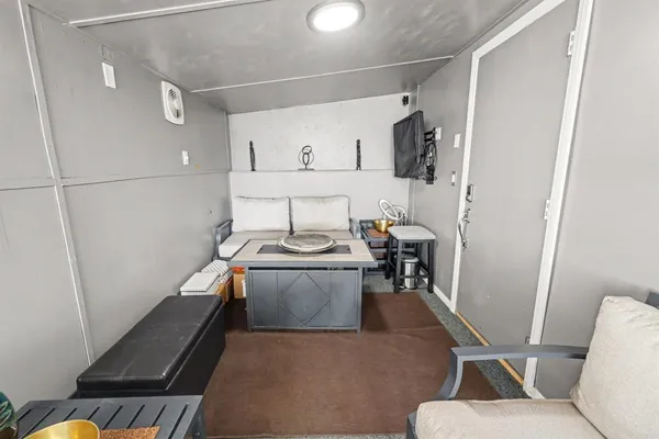 a living room with stainless steel appliances furniture and a window