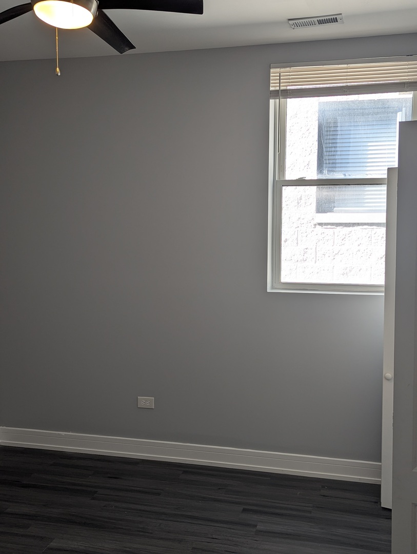 3925 South Indiana Avenue, Unit 3 Chicago, IL 60653 - Photo 7 of 11 a view of an empty room with wooden floor and a window