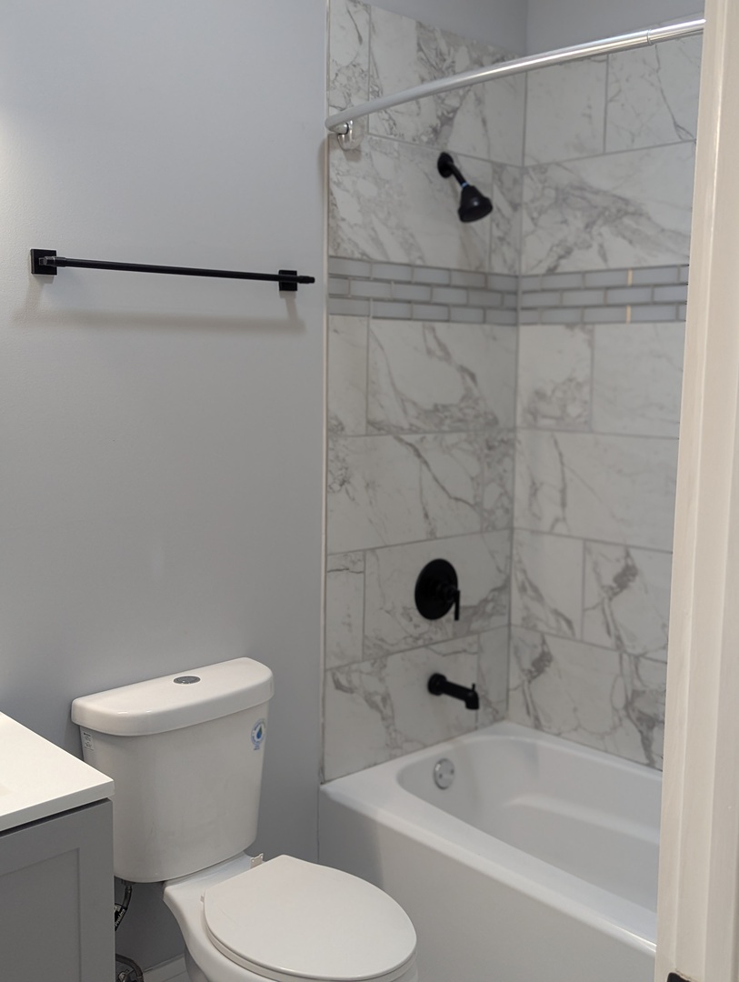 3925 South Indiana Avenue, Unit 3 Chicago, IL 60653 - Photo 9 of 11 a white bath tub sitting next to a toilet