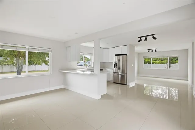 a kitchen with kitchen island a sink stove and refrigerator