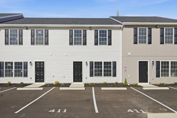 a front view of a house with a parking space