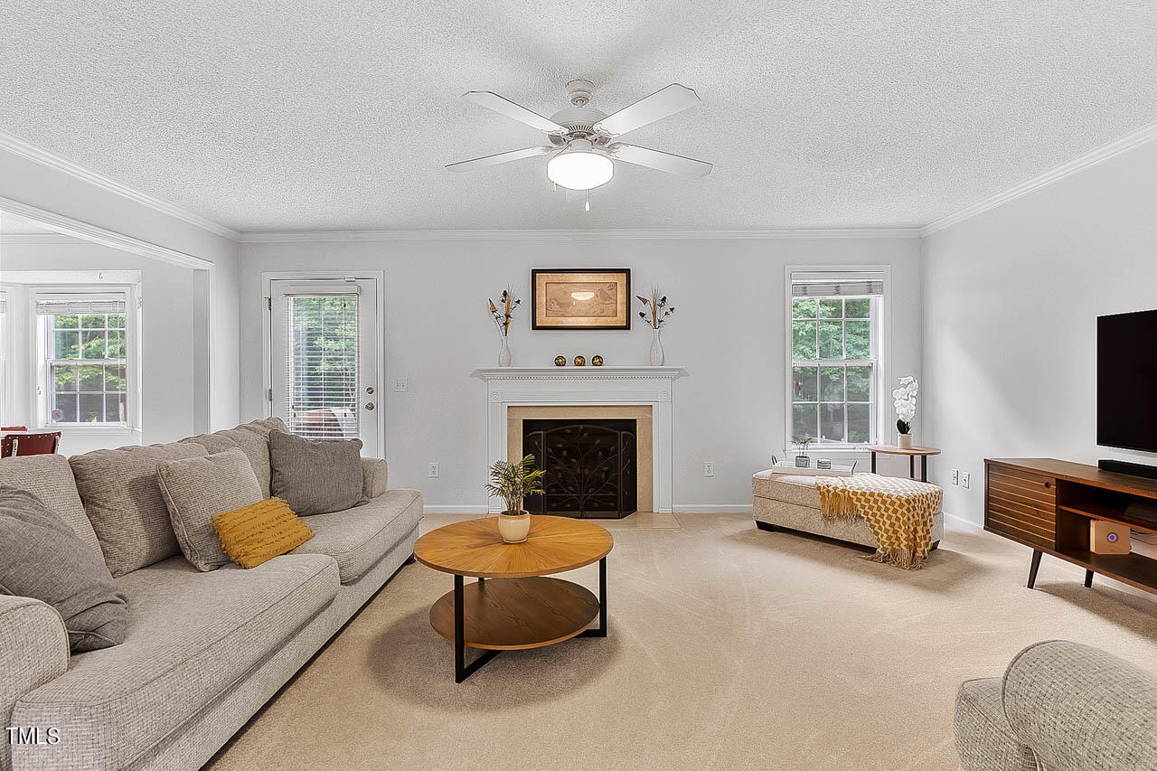 1060 Alderman Circle Raleigh, NC 27603 - Photo 6 of 30 a living room with furniture a fireplace and a flat screen tv