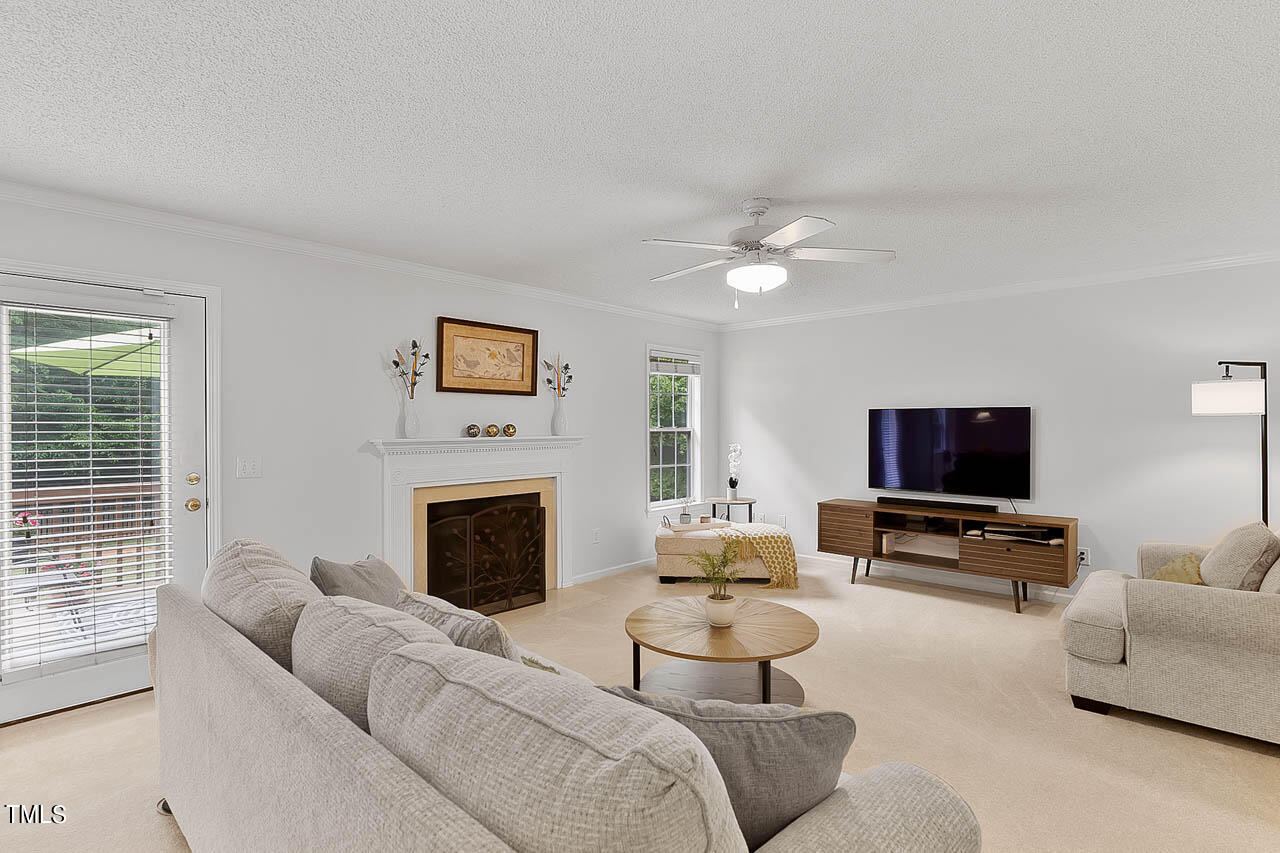 1060 Alderman Circle Raleigh, NC 27603 - Photo 8 of 30 a living room with furniture a fireplace and a flat screen tv