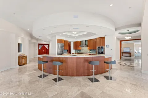 a large kitchen with stainless steel appliances kitchen island granite countertop a table and chairs in it