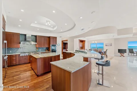 a large kitchen with kitchen island a large island a sink stainless steel appliances and cabinets