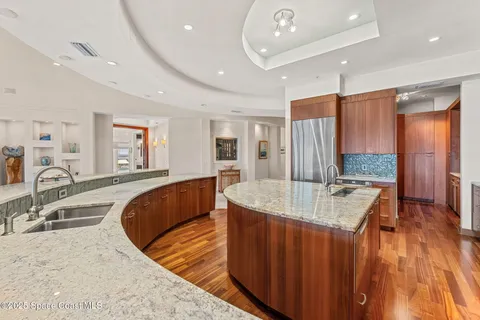 a kitchen with stainless steel appliances granite countertop wooden cabinets and a stove top oven with granite countertops