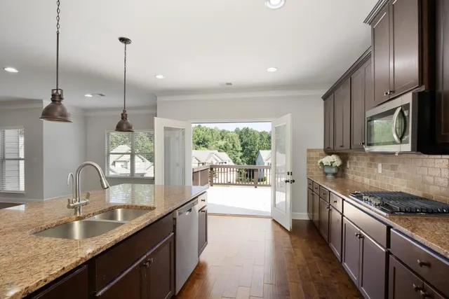 an empty room with wooden floor chandelier fan and windows